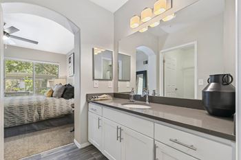 A white bathroom with a large mirror and a sink